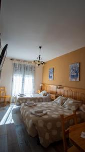 - une grande chambre avec 2 lits et une table dans l'établissement Casa Rural La Cerecera, à Los Navalucillos