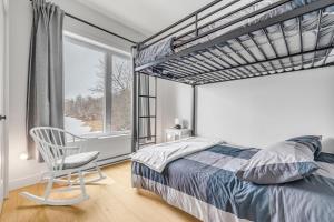 una camera da letto con un letto, una sedia e una finestra di Initial - the chalet - MSA SKI IN and OUT a Beaupré
