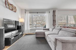 un soggiorno con divano e TV a schermo piatto di Initial - the chalet - MSA SKI IN and OUT a Beaupré