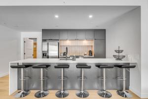 una cucina con una grande isola con sgabelli da bar di Initial - the chalet - MSA SKI IN and OUT a Beaupré