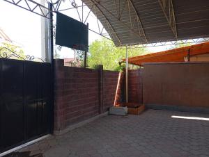 a patio with a fence and a basketball hoop at happy home in Bishkek +5 photos