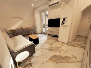 a living room with a couch and a television at U TIGRU - Luxe au cœur d'un village du Cap Corse in Luri