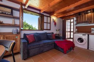 a living room with a couch and a washing machine at Casa de pedra na natureza - Portas da Levada B in São Vicente