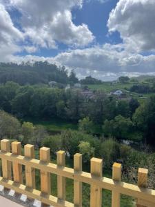 a wooden fence with a view of a field at Piso acogedor con vistas in Val do Dubra