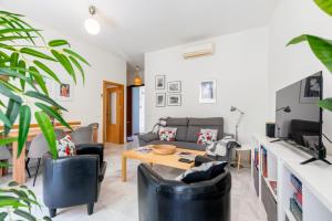 een woonkamer met een bank en een tafel bij Arenal Maestranza Apartment in Sevilla