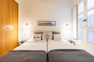 twee bedden naast elkaar in een slaapkamer bij Arenal Maestranza Apartment in Sevilla