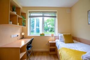 una camera da letto con una scrivania, un letto e una finestra di 33 - Spacious 2 Bed Apt, Sleeps 5 a Galway