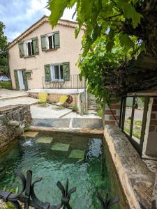 a pool of water in front of a house at Renovated Charming Farm with Activities Around in Lagrand
