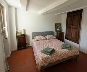 a bedroom with a bed with two green pillows on it at Renovated Charming Farm with Activities Around in Lagrand
