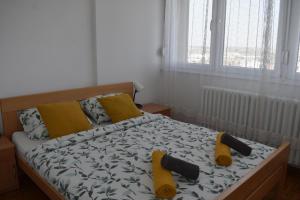 - une chambre dotée d'un lit avec des draps jaunes et noirs et des chaussures jaunes dans l'établissement Panoramico Novi Sad, à Novi Sad