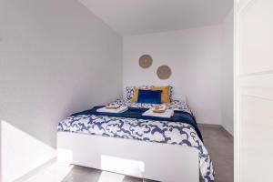 Un pequeño dormitorio con una cama con sábanas azules y blancas. en Lake View and Relaxation, Locarno, en Locarno