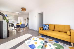 Una sala de estar con un sofá amarillo y una cocina. en Lake View and Relaxation, Locarno, en Locarno