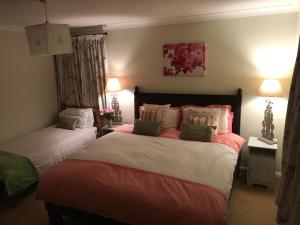 a bedroom with two beds and two lamps at Charlton Farm in Charlton