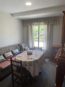 a living room with a table and a couch at Piso acogedor con vistas in Val do Dubra