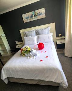a bed with flowers and a stuffed animal on it at Motse River Lodge in Vosburg