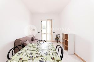 ein weißes Wohnzimmer mit einem Tisch und einer Couch in der Unterkunft Coral Reef in Torre Specchia Ruggeri