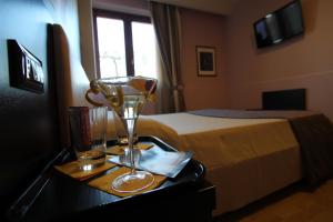 a bedroom with a bed and a table with a wine glass at Hotel Star in Monterotondo