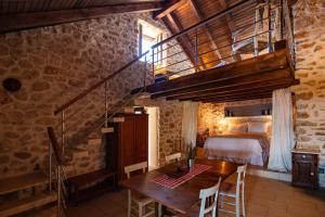 a bedroom with a bed and a wooden table and a staircase at Paradise cottage in Vinišće +30 photos