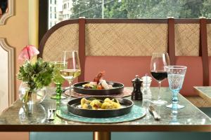 a table with two plates of food and glasses of wine at Grand Hotel Savoia in Genoa