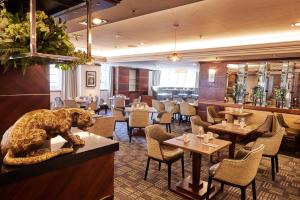 a restaurant with a bear statue sitting on a counter at The Marble Arch Hotel, by Thistle in London +50 photos