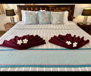 a bed with two mitts on top of it at Sun-kissed Emerald 4 bedroom villa in Betalbatim
