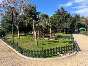 a wooden gazebo in a park with a fence at Cozy quiet studio near the sea in Athens