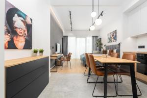 una cucina e una sala da pranzo con tavolo e sedie di MARGI Ether Apartament LUX POOL BALCONY a Stettino