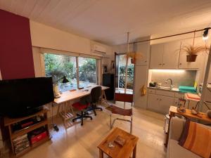 a living room with a desk and a kitchen at Cozy quiet studio near the sea in Athens