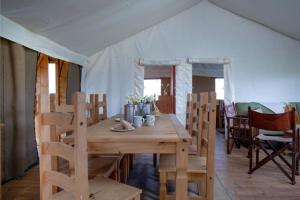 a wooden table and chairs in a tent at Treecreeper - Kittisford Barton in Wellington +31 photos