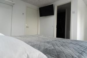 a bedroom with a bed with a television on the wall at Birkelse Hotel og Kro in Birkelse