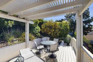 a patio with a table and chairs on a deck at Park Avenue Beach Life in Cayucos