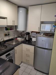 a kitchen with white cabinets and a white refrigerator at Impecable dpto a 2 cuadras de la playa in Viña del Mar
