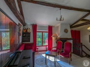 a living room with red curtains and a table and chairs at Villa jean-marie in Sengouagnet