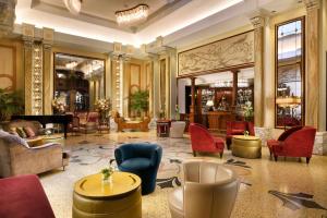 a lobby with a lot of chairs and tables at Grand Hotel Savoia in Genoa