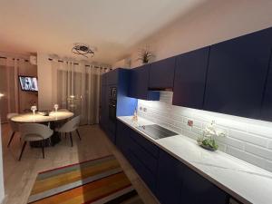 una cucina con armadi blu e tavolo da pranzo di 'Villa Xenia' HG25 - Relax and Enjoy the Golf Resort a Kouklia