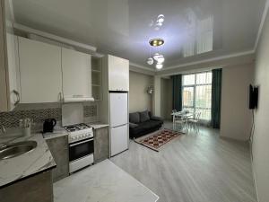 a kitchen with a stove and a couch in a room at Etno Naz in Bishkek +17 photos