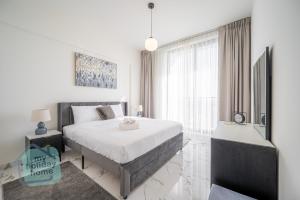 a bedroom with a bed and a large window at Private Beach 1BR-Yacht Club-Work Space-Pool-Gym in Ras al Khaimah