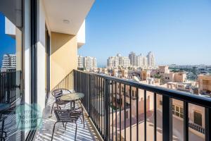 a balcony with chairs and a view of the city at Private Beach 1BR-Yacht Club-Work Space-Pool-Gym in Ras al Khaimah