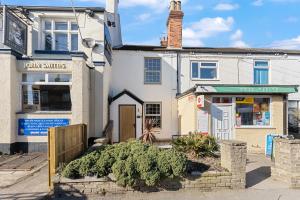 un piccolo edificio bianco con un cartello per un negozio di Pickin Cottage a Altofts