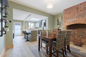 una sala da pranzo con tavolo e muro di mattoni di Pickin Cottage a Altofts