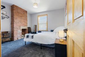 una camera da letto con un letto e un muro di mattoni di Pickin Cottage a Altofts