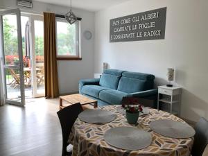 a living room with a table and a blue couch at Casa Vacanza Mattirolo - Castagneto Po in Castagneto Po