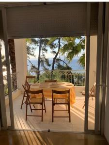 a table and chairs on a patio with a view of the ocean at Villa Lesvos 30 meters to the Sea in Pligónion