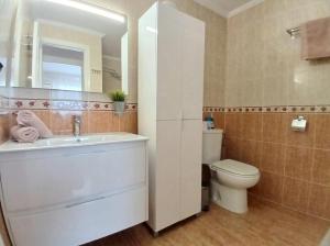 a bathroom with a sink and a toilet and a mirror at Appartement cosy avec 2 chambres et piscine commune in San Pedro del Pinatar +9 photos