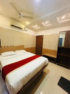 a bedroom with a large bed and a piano at Crown Inn in Bengaluru