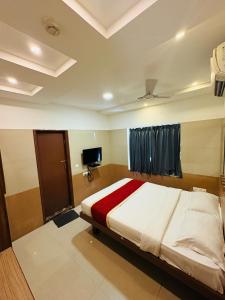 a bedroom with a large bed and a tv at Crown Inn in Bengaluru