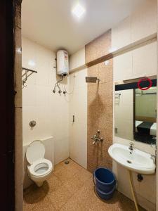 a bathroom with a toilet and a sink at Crown Inn in Bengaluru