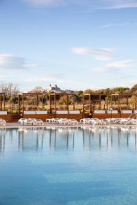 a pool of water with a group of white chairs at Hotel Cap Negret in Altea
