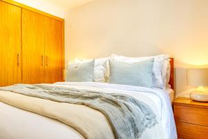ein Schlafzimmer mit einem weißen Bett mit einem Holzschrank in der Unterkunft Casa do Pinheiro II, a Home in Madeira in São Vicente