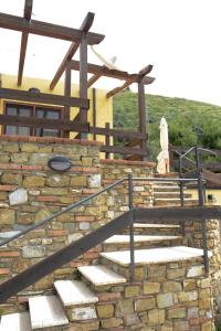 una rampa di scale in pietra con ringhiera in legno di Appartamenti Le Giare Acciaroli ad Acciaroli